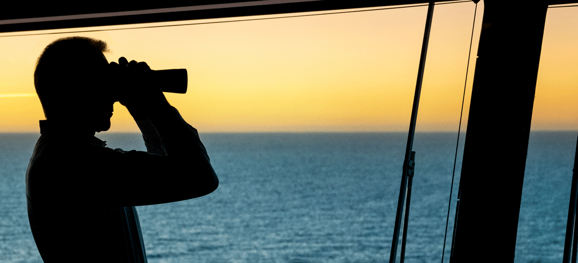 Captain with the binocular browsing the horizon