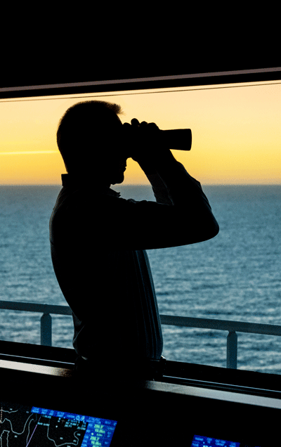 Captain with the binocular browsing the horizon